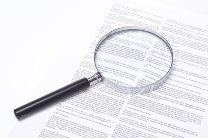 Magnifying glass lying on a legal contract